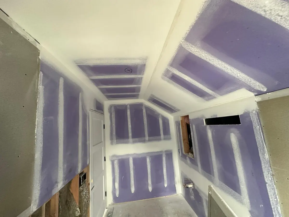 Drywall taping in progress in a stairwell