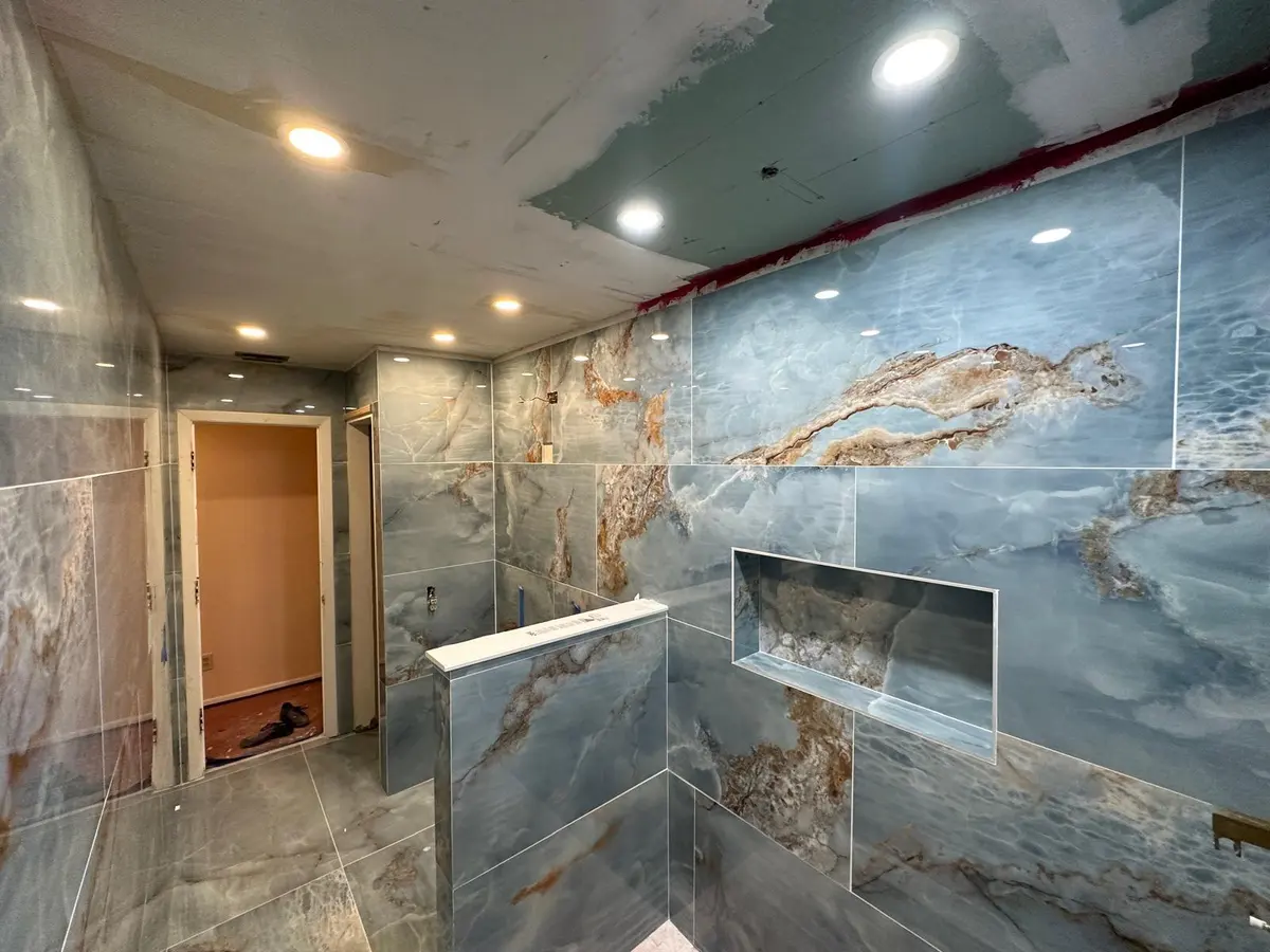 Finished walk-in shower with marbled tile and glass door
